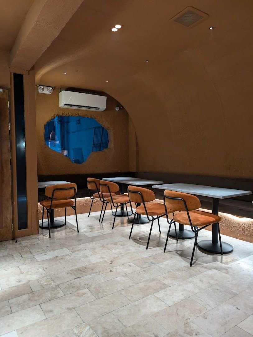 Grotto Lounge interior with cave-inspired walls, warm lighting, and velvet seating